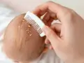 Delikatne czesanie główki niemowlęcia, by usunąć żółtawe łuski, które mogą świadczyć o ciemieniu.