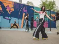 Eine Gruppe junger Leute genießt das Roller-Skating in Berlin vor einer bunten Wandmalerei.
