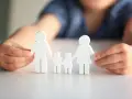 Dziecko układa figurki rodziny, symbolizując troskę i wsparcie. Wskazówki jak postępować z dzieckiem autystycznym.