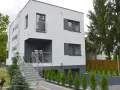 Nowoczesny dom z biało antracytową elewacją, schodami i metalową klatką schodową.