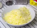 Queso rallado en un bol blanco, listo para hacer fondue.