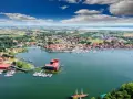 Malownicze miasta na Mazurach, które warto odwiedzić, rozciągają się wzdłuż jeziora. Widok na port z żaglówkami i zabytkową zabudowę.