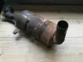 Zardzewiały, zużyty filtr DPF na drewnianym blacie.