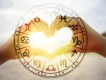 Dłonie tworzą serce, a w tle koło zodiaku z symbolem koziorożca. Miłość i astrologia, czyli koziorożec i koziorożec w sercu.