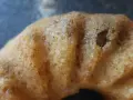 Närbild på en gyllene sockerkaka med kardemumma, med synliga små prickar av kryddan i den porösa kakan.