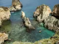Idealne portugalia wakacje: łódka wśród skalistych wysepek i turkusowej wody.