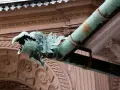 Zielony, miedziany rzygacz w kształcie smoczej głowy odprowadza wodę z rynny.