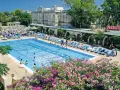 Profitez de vos vacances scolaires à Malte au bord de cette piscine animée, entourée de transats et de végétation luxuriante.