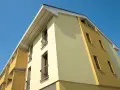 Edificio moderno con facciata bicolore, protetta da vernice isolante termica Mapei, sotto un cielo azzurro.