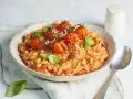 Cremiges Tomaten Risotto, garniert mit frischen Basilikumblättern und gerösteten Kirschtomaten. Ein Genuss für jeden Liebhaber italienischer Küche.