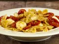Farfalle con pomodorini confit, mozzarelline e un tocco di acciughe. Un piatto semplice e gustoso.