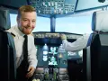 Uśmiechnięty pilot w kabinie samolotu, obok drugiego pilota przy panelu sterowania.