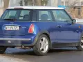 Niebieski Mini Cooper R50 z białym dachem, zaparkowany na zaśnieżonej drodze.