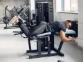 Man utför liggande lårcurl på ett gym.