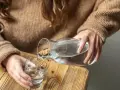 Dłonie nalewają wodę z karafki do szklanki. Pamiętaj, by stay hydrated.
