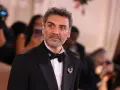 Oscar Isaac w eleganckim smokingu, gotowy na premierę swoich najnowszych filmów, seriali i programów.