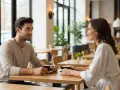 Un homme et une femme sirotent un café, leurs regards échangés suggèrent un signe de désir chez l'homme.