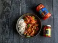 Miseczka z ryżem i kurczakiem po koreańsku, z dodatkiem kimchi i sosu chili.