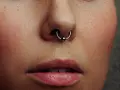 Zbliżenie na twarz z kolczykiem w nosie (septum). Czy septum boli? To pytanie zadaje sobie wiele osób przed piercingiem.