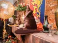 Czapka Mówiąca, złoty balon i bukiet róż tworzą magiczną atmosferę na weselu w stylu Harry'ego Pottera.