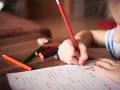 Dziecko zmagające się z dysleksją, dysgrafią, dysortografią i dyskalkulią pisze kredkami.