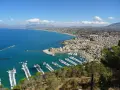Vista panoramica di Castellammare del Golfo, con il castello, il porto turistico pieno di barche e la costa siciliana.