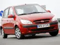 Czerwony Hyundai Getz na drodze. Kierowca za kierownicą, widoczna tablica rejestracyjna WN 61592.