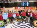 Drużyna Portugalii w piłce ręcznej na wózkach świętuje zwycięstwo. Na ekranie wynik meczu, a w tle flagi państwowe i logo EHF.