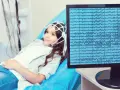 Dziewczynka z czepkiem EEG leży na kozetce, a na monitorze widać zapis fal mózgowych. Badanie pomaga zrozumieć zespół Aspergera a wynik EEG.