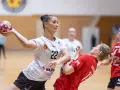 Piłkarka Suzuki Korona Handball Kielce rzuca piłkę. Rywalka w czerwonej koszulce próbuje ją zablokować.