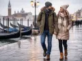 Coppia passeggia a Venezia, con gondole sullo sfondo. Perfetto esempio di come vestirsi a Venezia in inverno: cappotti caldi, sciarpe e berretti.