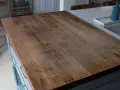 A close-up of a well-used butcher block countertop, showing the grain and minor scratches. This image illustrates how to clean butcher block countertops for a beautiful finish.