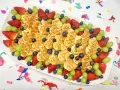Herzförmige Waffeln mit Erdbeeren, Blaubeeren und grünen Trauben auf einem Teller – ein bunter obstteller kinder für jeden Anlass.