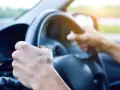 Dłoń trzyma smartfon z mapą i pinezką lokalizacji.