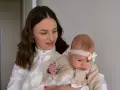Elegancka mama z niemowlakiem. Inspiracja, jak ubrać się na chrzciny jako gość: biała koszula, subtelne dodatki.