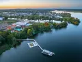 Luftaufnahme der Havel Therme mit einem schwimmenden Pool auf dem Wasser. Ein idyllisches Bild der Entspannung am See.
