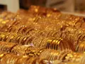 Una ricca collezione di bracciali d'oro, molti con il marchio 750, brillano sotto la luce, creando un'abbagliante esposizione di lusso.