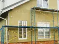 Budynek w trakcie ocieplania wełną mineralną, z rusztowaniem. Czy ocieplenie budynku wymaga pozwolenia na budowę?
