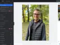Mężczyzna w okularach uśmiecha się na tle parku. Interfejs programu Fotor oferuje darmowy program do obróbki zdjęć po polsku.