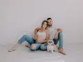 Ciąża w obiektywie laura kania fotografia: przyszli rodzice z pieskiem siedzą na podłodze.