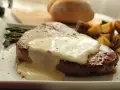 Jugosa ternera en salsa cremosa, acompañada de espárragos y patatas asadas. Un plato principal delicioso.