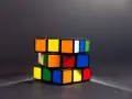 En färgglad speed cube ligger på ett mörkt underlag.