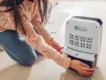 Donna controlla il serbatoio del deumidificatore, sperando che non faccia acqua.