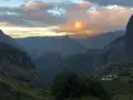Al tramonto, le montagne della "diagonale des fous" si tingono di rosa. Un villaggio si intravede tra le valli verdi.