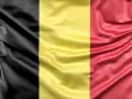 Falująca belgijska flaga z pionowymi pasami: czarnym, żółtym i czerwonym.