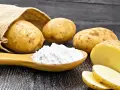 Kartoffeln und ein Löffel voller Kartoffelstärke, eine vielseitige kartoffelmehl alternative für Küche und Haushalt.