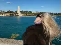Kobieta z blond włosami podziwia pomnik i morze w Brindisi. Warto zobaczyć to miejsce!