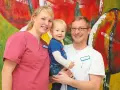 Glückliche Familie vor bunter Kunst. Das Bild thematisiert das Arbeitsrecht bei Schichtarbeit mit Kind.