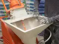 Pracownik zasypuje maszynę do tynków. Sprawdź tynki maszynowe cena za m2 z materiałem.