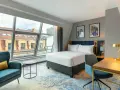 Nowoczesny pokój hotelowy z dużym oknem, łóżkiem i biurkiem. Czy trzeba być pełnoletnim, aby wynająć hotel? Tak, zazwyczaj tak.